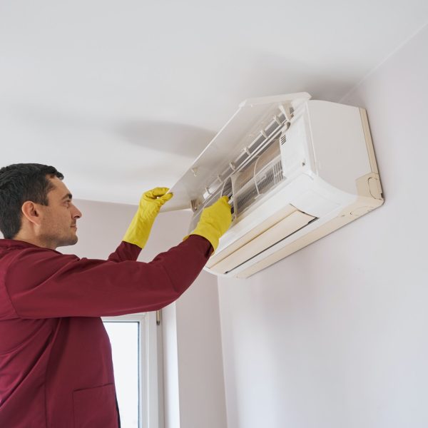 Concentrated cleaner in rubber gloves cleaning air-conditioning unit Concentrated cleaner in rubber gloves cleaning air-conditioning unit