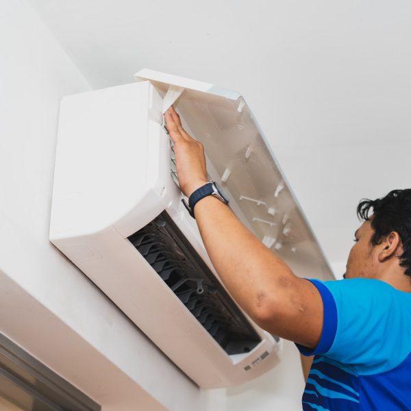 Male technician cleaning air conditioner indoors Male technician cleaning air conditioner indoors