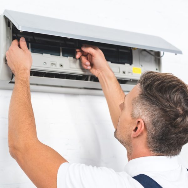repairman fixing air conditioner on wall repairman fixing air conditioner on wall
